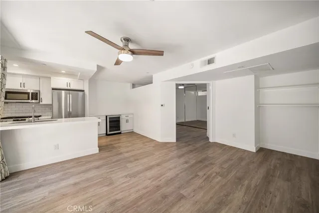 a view of a kitchen with wooden floor and electronic appliances
