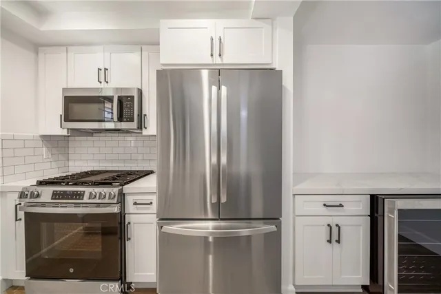 a kitchen with stainless steel appliances wooden cabinets and a stove
