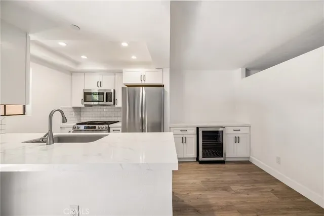 a kitchen with granite countertop a refrigerator and a sink