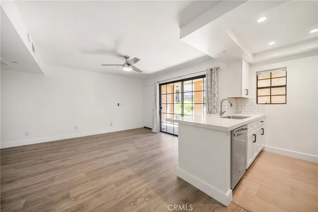 a kitchen with a sink cabinets wooden floor and a window