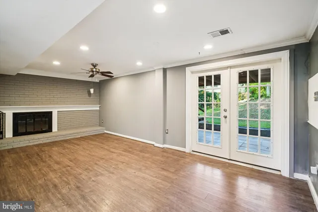 a view of an empty room with a fireplace and a window