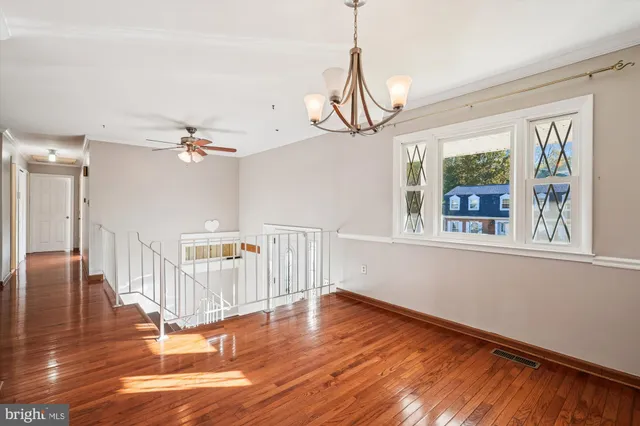a view of a livingroom with wooden floor and a chandelier
