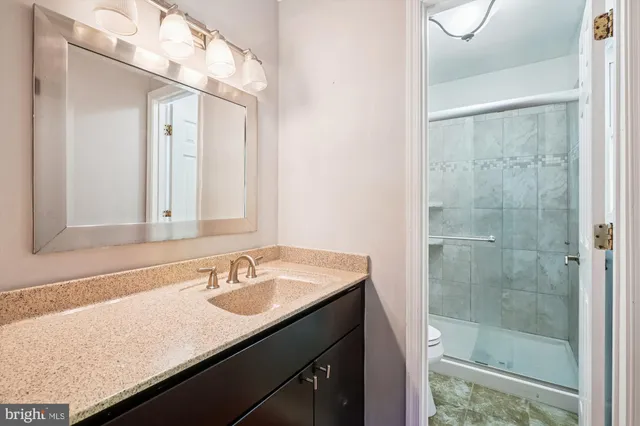 a bathroom with a sink vanity granite and a mirror