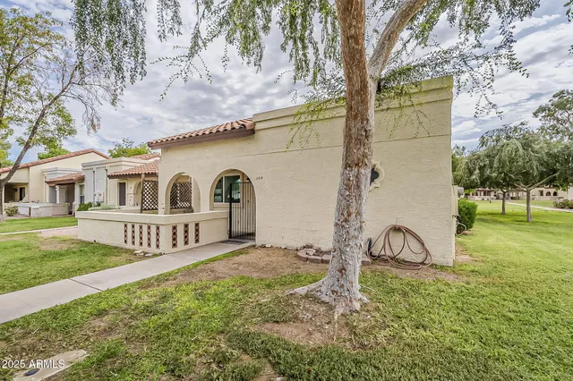 a white house that has tree in front of it