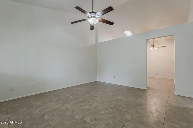 an empty room with chandelier fan