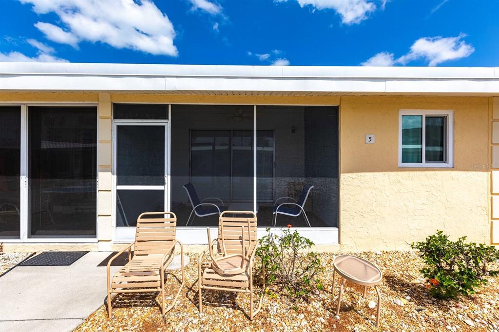 6006 Midnight Pass Road, Unit 5 Sarasota, FL 34242 - Photo 16 of 22 a view of a patio with table and chairs with wooden floor and fence