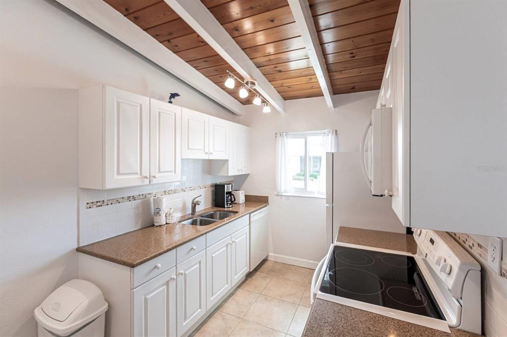 6006 Midnight Pass Road, Unit 5 Sarasota, FL 34242 - Photo 6 of 22 a kitchen that has a sink and a stove in it