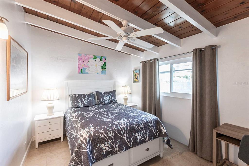 6006 Midnight Pass Road, Unit 5 Sarasota, FL 34242 - Photo 9 of 22 a large bed sitting in a bedroom next to a window