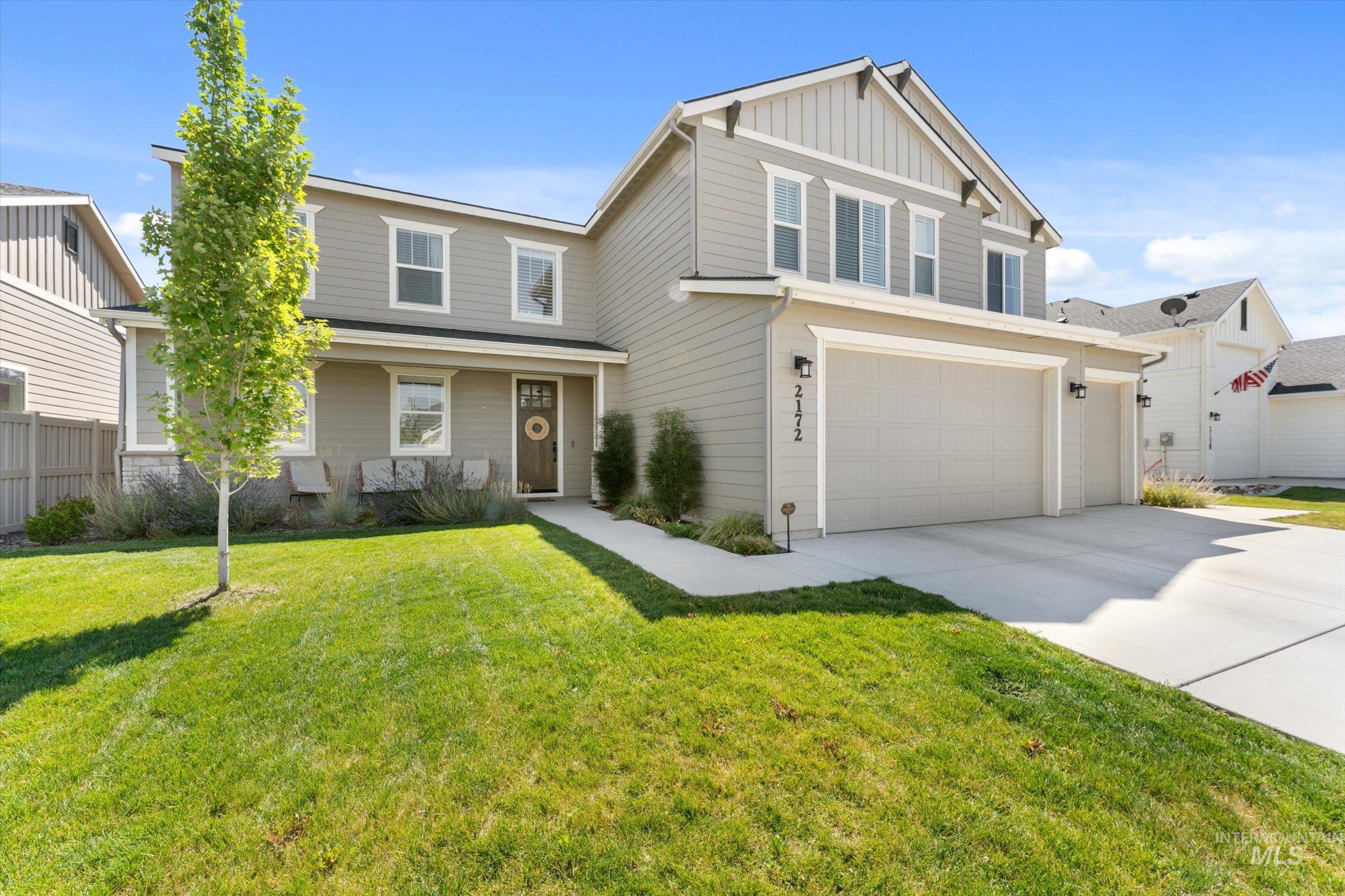 2172 Savoy Court Middleton, ID 83644 - Photo 2 of 46 Contemporary kitchen featuring a gas range, subway tile backsplash, white shaker cabinetry, light wood-finish flooring, and a stainless steel refrigerator