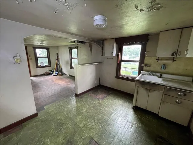 an empty room with wooden floor and entrance