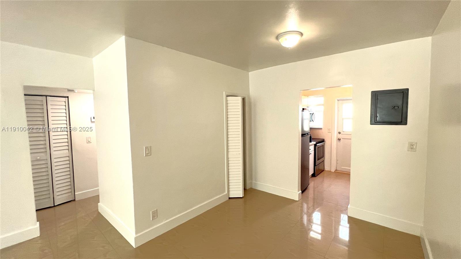 8235 Crespi Boulevard, Unit 1 Miami Beach, FL 33141 - Photo 5 of 24 a view of a hallway with bathroom and wooden floor