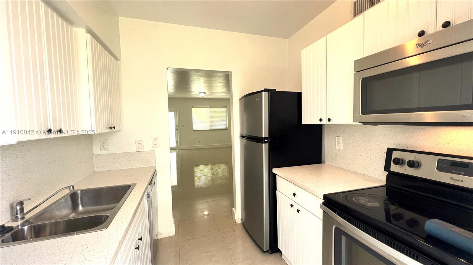 8235 Crespi Boulevard, Unit 1 Miami Beach, FL 33141 - Photo 6 of 24 a kitchen with a refrigerator stove and microwave