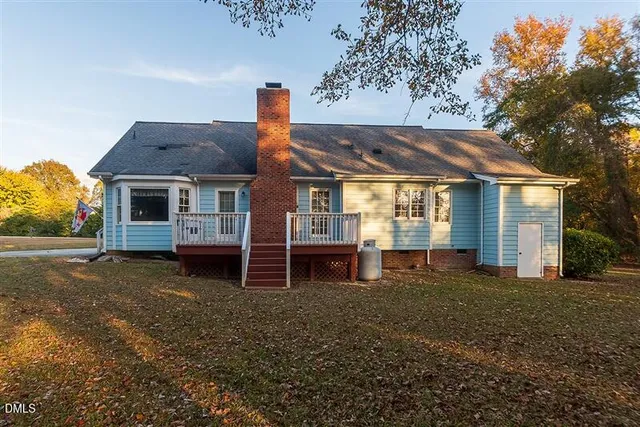a view of a house next to a big yard with large trees