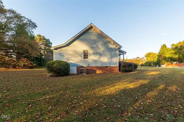 a view of a house with a yard and large trees