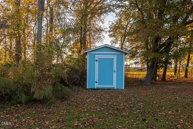 a view of a house with backyard and trees