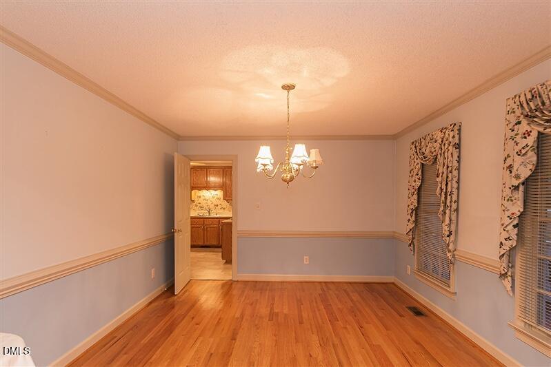 9908 Huntwyck Drive Raleigh, NC 27603 - Photo 8 of 32 a view of a room with wooden floor and white walls