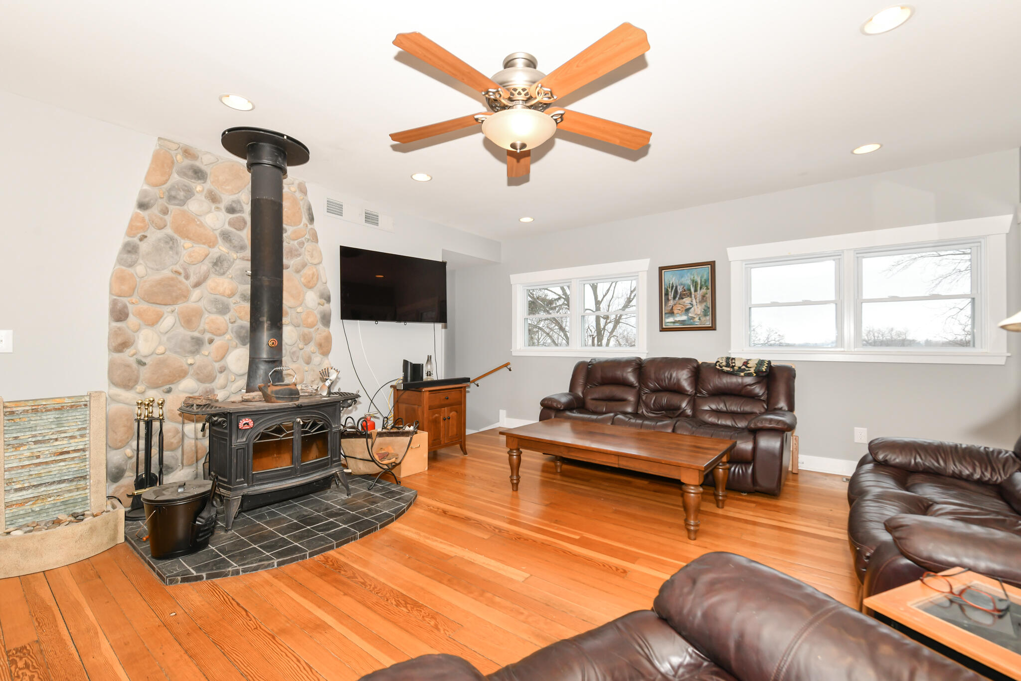 4222 Maple Drive Delavan, WI 53115 - Photo 9 of 44 Vermont casting wood burner adds a cozy touch to your light and bright great room with hardwood floors.