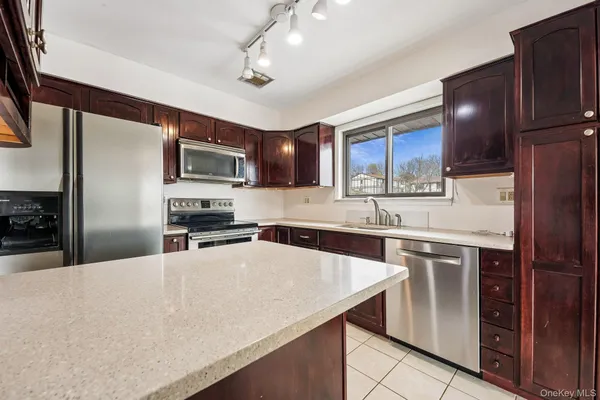a kitchen with stainless steel appliances granite countertop a sink refrigerator and microwave