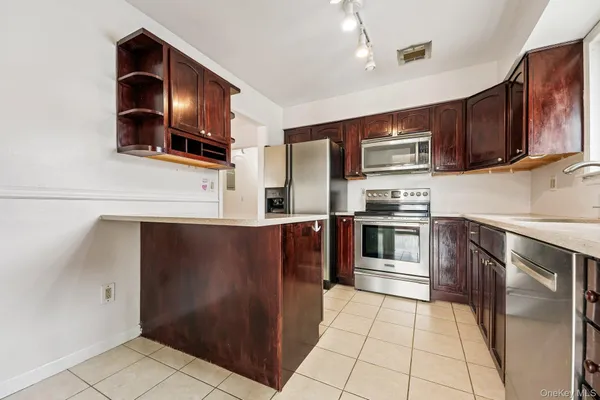 a kitchen with stainless steel appliances granite countertop a refrigerator and a stove