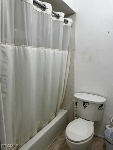a white toilet sitting next to a shower