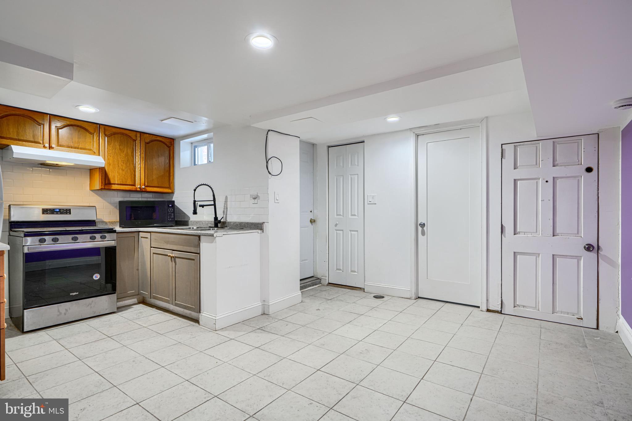 804 Quail Street Baltimore, MD 21224 - Photo 21 of 39 a kitchen with white cabinets and appliances
