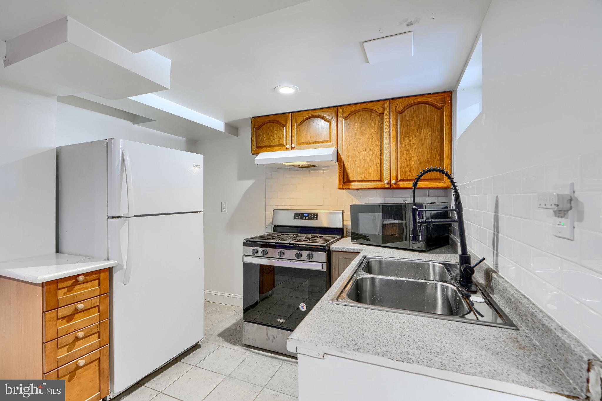 804 Quail Street Baltimore, MD 21224 - Photo 25 of 39 a kitchen with stainless steel appliances a stove a refrigerator and a sink