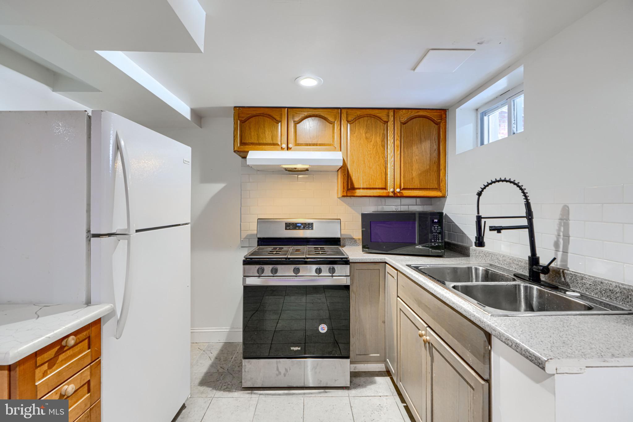 804 Quail Street Baltimore, MD 21224 - Photo 26 of 39 a kitchen with stainless steel appliances granite countertop a sink a stove and a refrigerator