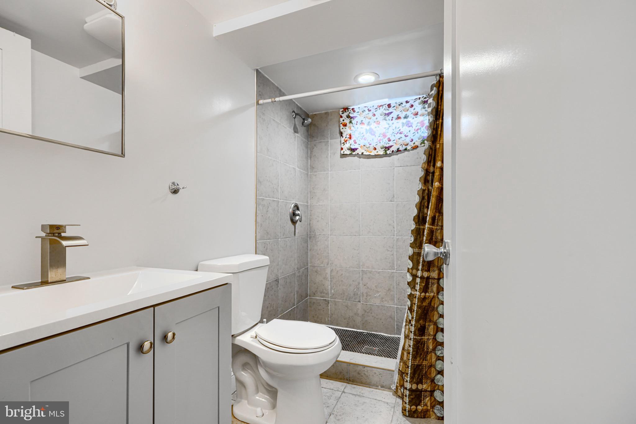 804 Quail Street Baltimore, MD 21224 - Photo 28 of 39 a bathroom with a sink a toilet and shower