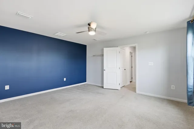 a view of an empty room with a ceiling fan