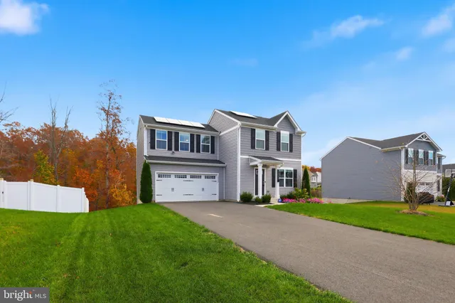 a front view of a house with a garden and yard