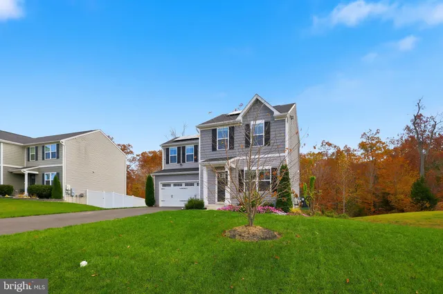 a view of a house with a big yard and large trees