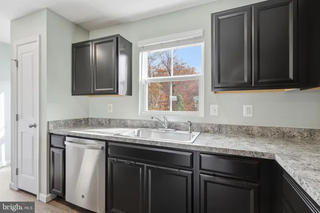 a kitchen with granite countertop cabinets sink and window