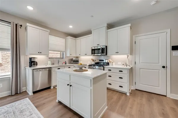 a kitchen with white cabinets and white appliances