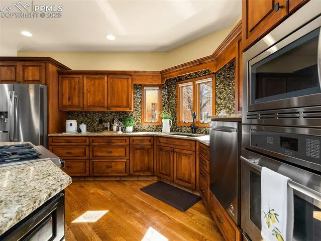 a kitchen with stainless steel appliances granite countertop a stove a sink and a microwave