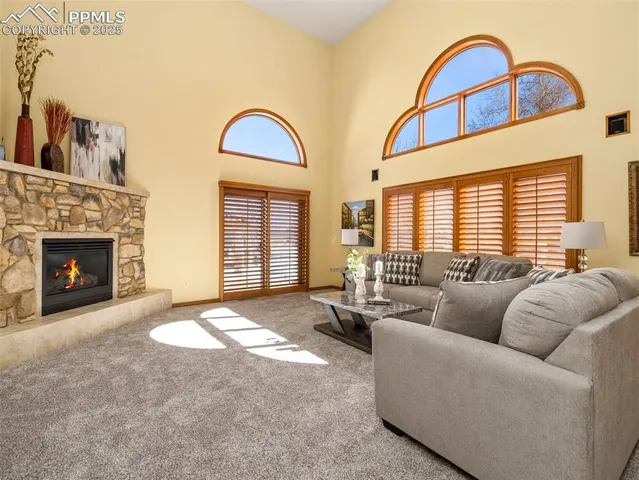 a living room with furniture a fireplace and a large window