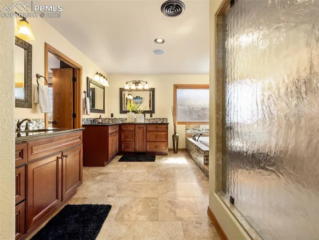 a large kitchen with kitchen island a large window a sink and stainless steel appliances