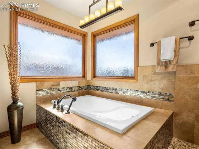 a bathroom with a tub a double vanity sink and mirror