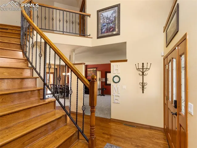 a view of staircase with wooden floor and a chandelier