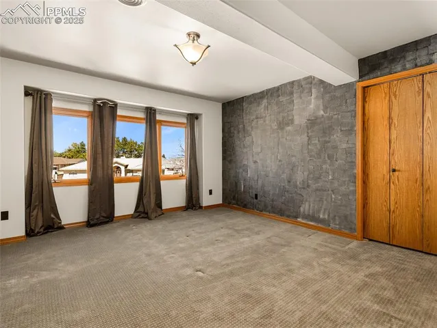 a view of an empty room with window and stairs