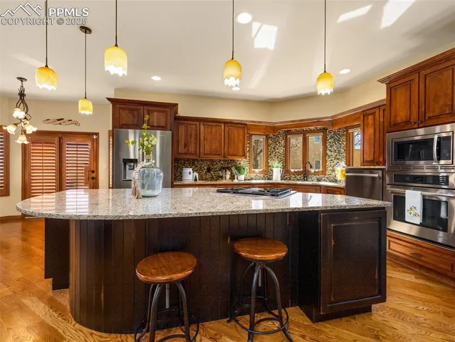 a kitchen with stainless steel appliances granite countertop counter space a sink cabinets and wooden floor