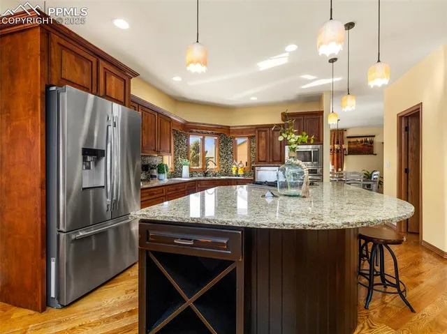 a kitchen with stainless steel appliances granite countertop a refrigerator a stove a sink and a refrigerator