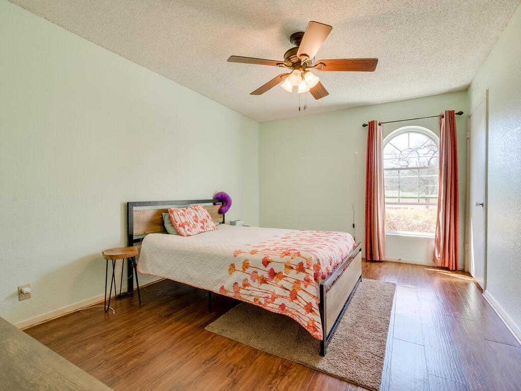 Hardwood floors and a gracefully arched window complete this comfortable bedroom.