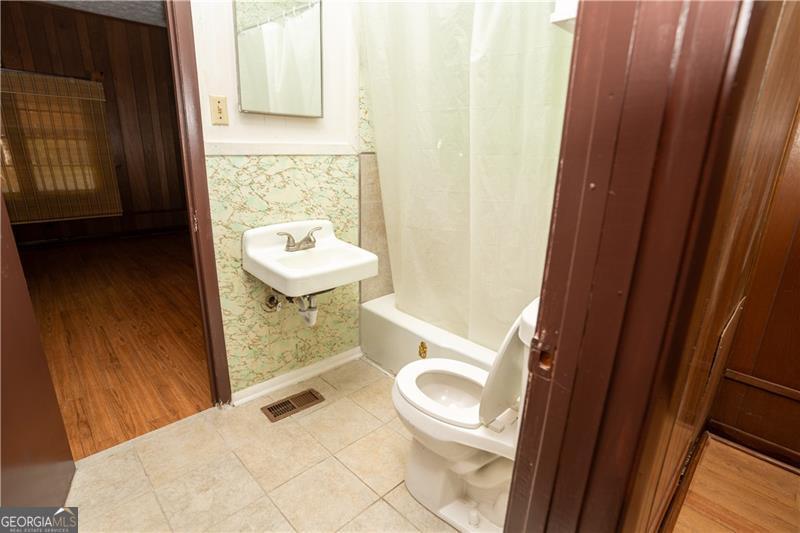 305 Wolfe Street Dublin, GA 31021 - Photo 15 of 27 a bathroom with a sink a toilet and a shower