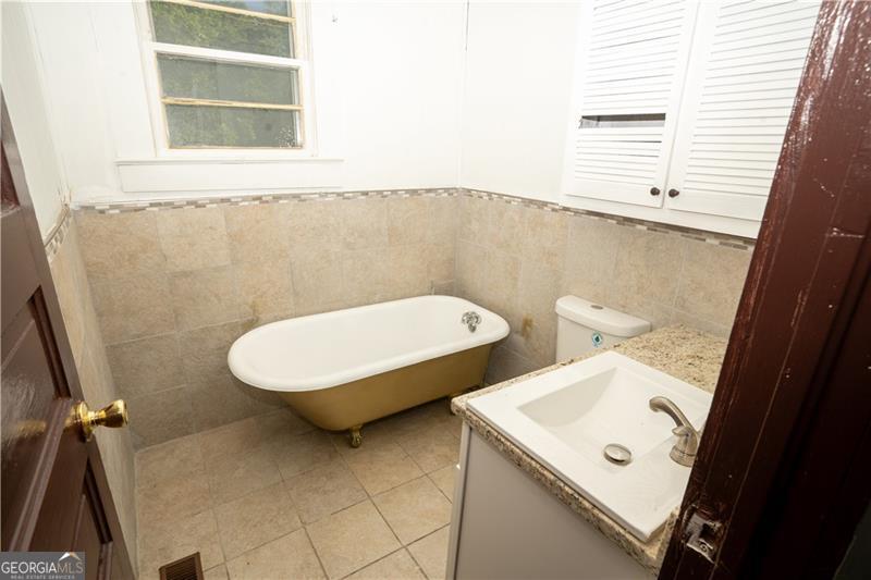 305 Wolfe Street Dublin, GA 31021 - Photo 19 of 27 a bathroom with a toilet sink and mirror