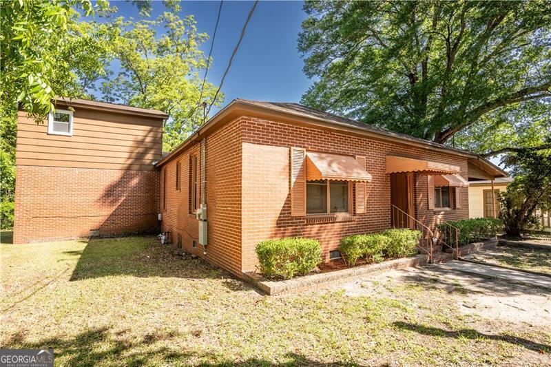 305 Wolfe Street Dublin, GA 31021 - Photo 2 of 27 a backyard of a house with potted plants and large tree