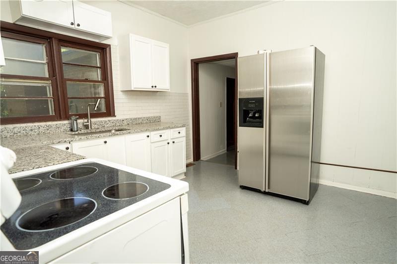 305 Wolfe Street Dublin, GA 31021 - Photo 6 of 27 a kitchen with a sink and refrigerator