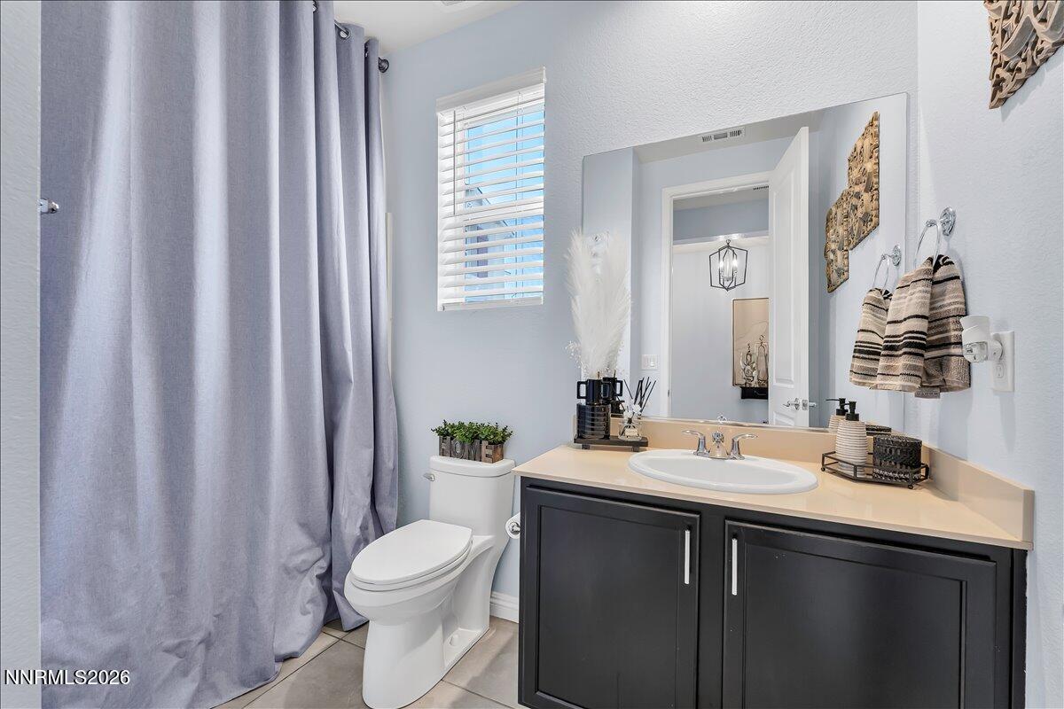 2139 Roaring Fork Court Sparks, NV 89436 - Photo 16 of 42 a bathroom with a sink a toilet and shower curtain
