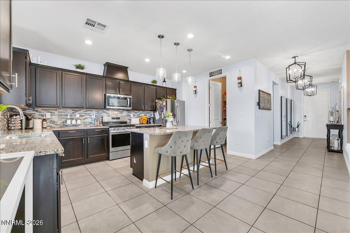 2139 Roaring Fork Court Sparks, NV 89436 - Photo 10 of 42 a kitchen with kitchen island granite countertop a sink cabinets and stainless steel appliances