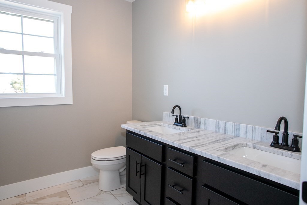 38 D Edson Road Oakham, MA 01068 - Photo 30 of 36 a bathroom with a granite countertop sink a toilet and a window