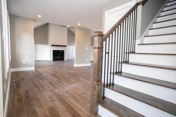 a view of a hallway with wooden floor and staircase